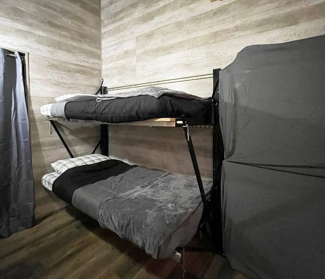 Bunk beds in the living area, made up in grey